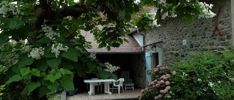 L'entrée côté terrasse, sous les ombrages