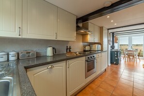 First & Last, Trimingham: Galley kitchen leading to dining conservatory