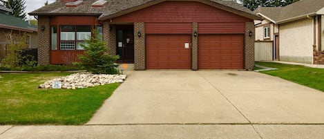 Street view of front of house and large driveway for parking 