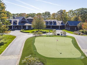 The putting green in the center of the three buildings on the property.