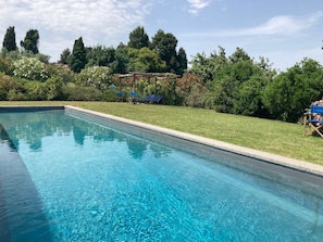 The pool area, entirely fenced and enframed by plants and flowers