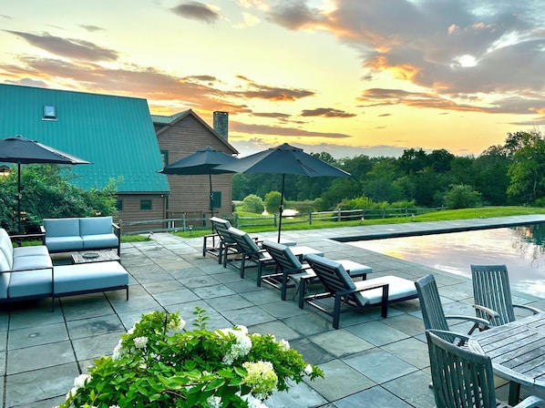 Pool area with multiple seating areas and additional charcoal grill