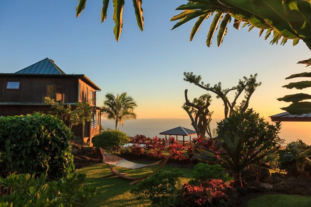 Sunset views over a tropical garden overlooking the ocean and the best Kona Hawaii beaches