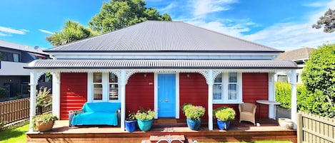 sunny north facing veranda with comfty couch, flowers and lush grass