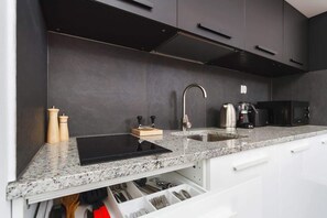 A close-up showcasing the high-quality finishes of the kitchen, including sleek cabinet fronts and modern black hardware.