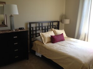 bedroom with high quality linens, closet, small TV and 8-drawer dresser