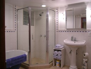 A sparkling clean large bathroom with a tub and walk-in shower.