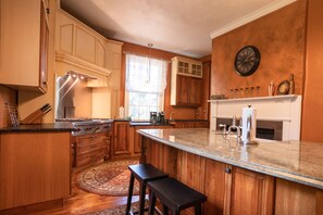 Huge custom granite island w farmhouse sink.  A chef’s dream kitchen!