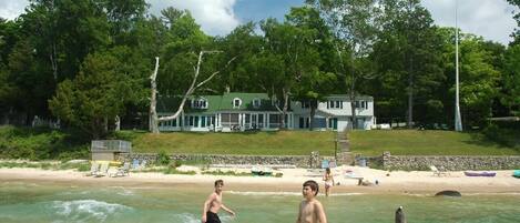 Kids playing in the surf with The Jolli-Lodge in the background (photo 2017)