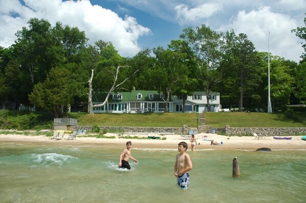 Kids playing in the surf with The Jolli-Lodge in the background (photo 2017)