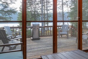 Deck viewed from screened porch, and lake just beyond.