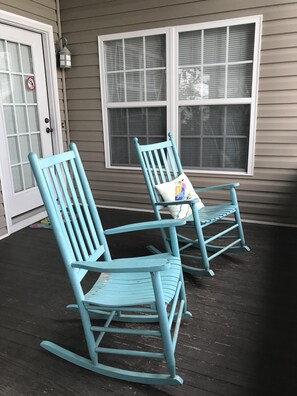 Screened porch with ceiling fan and rocking chairs.