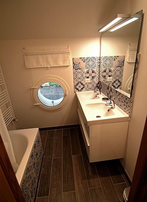 Salle de bain avec baignoire et double vasque