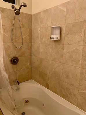 Jacuzzi tub in marbled master bathroom