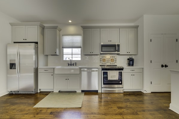 Kitchen is fully equipped with stainless steel appliances and a farm sink.