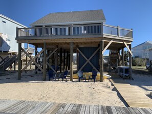 A large deck to lounge on as well as seating in the sand below.