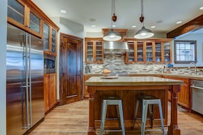 Eye-catching kitchen with hard wood cabinets, stylish back splash, and concrete counter tops.