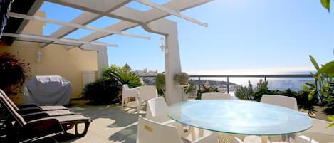 Southfacing terrace with outdoor dining area, sun loungers, gas barbecue and sea views