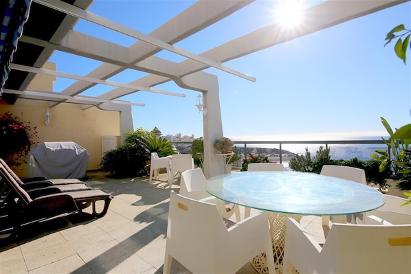 Southfacing terrace with outdoor dining area, sun loungers, gas barbecue and sea views