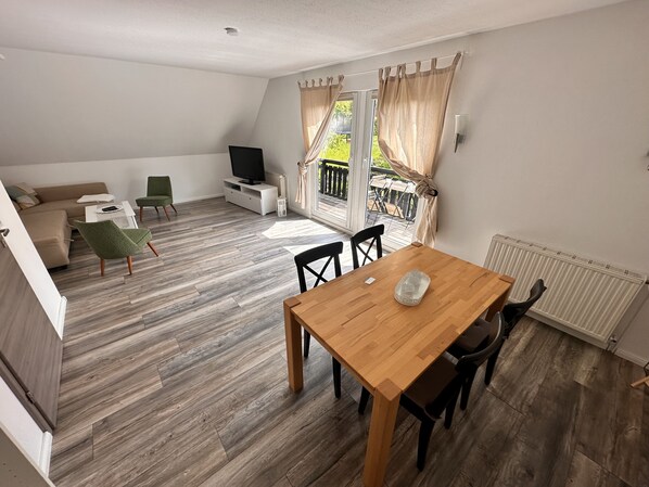 Wohnzimmer mit großzügigem Essbereich und großem TV