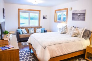 Cozy sitting couch and a large dresser. And a amazing waterfront view.