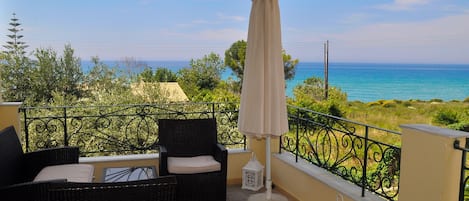 Auf der 1. Etage. Überdachte Terrasse mit Gartenmöbeln und Blick aufs Meer.