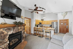 Living area featuring a mounted TV over a gas fireplace, and queen sleeper sofa.