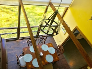 View of the dining room through a two story window from the second floor.