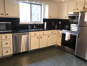 Kitchen with new appliances. Attached is a two story dining room window. 