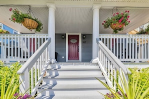 Walk between the overflowing flower pots onto the beautiful covered front porch!