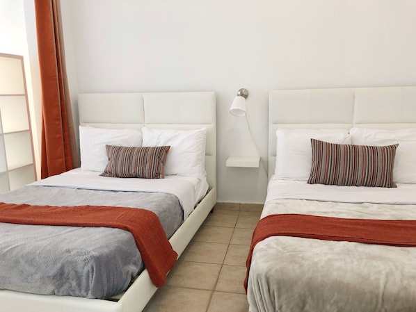 Dormitorio con dos camas Queen en el que caben 2 personas en cada una, tiene AC.