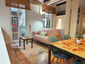 The living area of the loft features a light and airy feel with natural light streaming in through large windows. The image provides a glimpse of the overall ambiance of the loft, showcasing its modern design and comfortable furnishings.