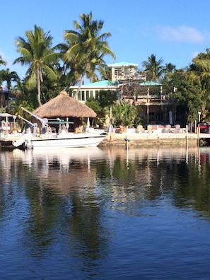 view of house, tiki hut and dock from across the lagoon