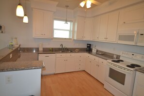 Spacious and bright kitchen with lots of cabinets.