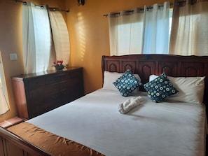 King sized masterbedroom where natural light pours in from the overhead skylight