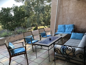 Salon de jardin sur la terrasse surplombant le jardin. 