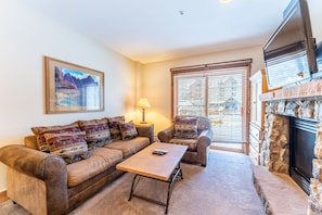 Living area featuring gas fireplace, flat screen TV and access to the private balcony.