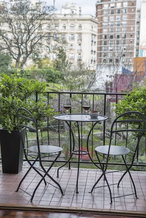 A little french balcony seeing to a green space.