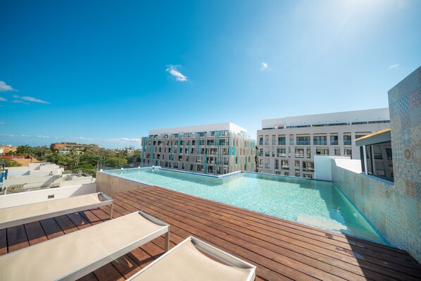 Common area rooftop pool with lounge chairs
