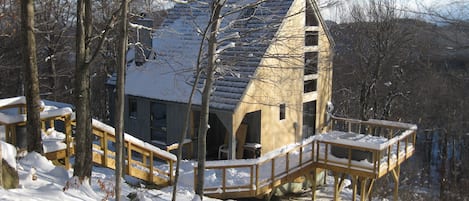 Exterior view of House. Stairs from Driveway and Deck. 