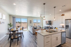 Kitchen View of Living Room - The living room is conveniently adjacent to the kitchen. There is also access to the back patio which has a BBQ grille suitable for all your favorite BBQ dishes.