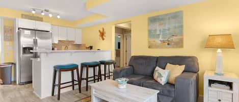 Newly renovated, open kitchen & living room with all new appliances, breakfast bar, 4-seat dining table, couch, accent chair and flat screen smart Roku TV.