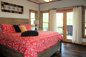 Main floor bedroom with king bed and French doors that open onto covered porch.