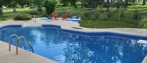 A large pool with a diving board, a nice asset for the summer!