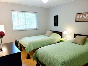 The second sleeping area features 2 single beds and a desk.