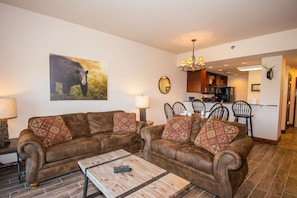 Comfortable seating in the living room with 55" Flatscreen TV and electric fireplace.