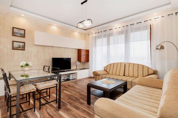 A comfortable living room with a beige sofa, matching armchairs, and a coffee table, creating an inviting space for relaxation.