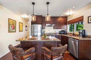 Kitchen island, counter stools, refrigerator, microwave and toaster