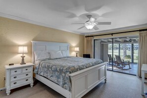 - Rest easy in this elegant bedroom with a plush king bed, matching nightstands, and ceiling fan for comfort
- Sliding doors open directly to a patio with rocking chairs and green views
- Perfect for lazy mornings or peaceful sunset wind downs