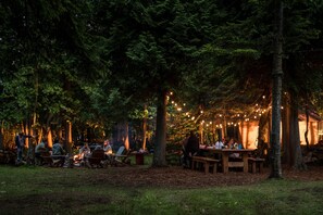 The outdoor entertainment area is the star of the show offering a 15 ft farm table under twinkly lights and a fire pit making this the perfect spot for s'mores and game night.